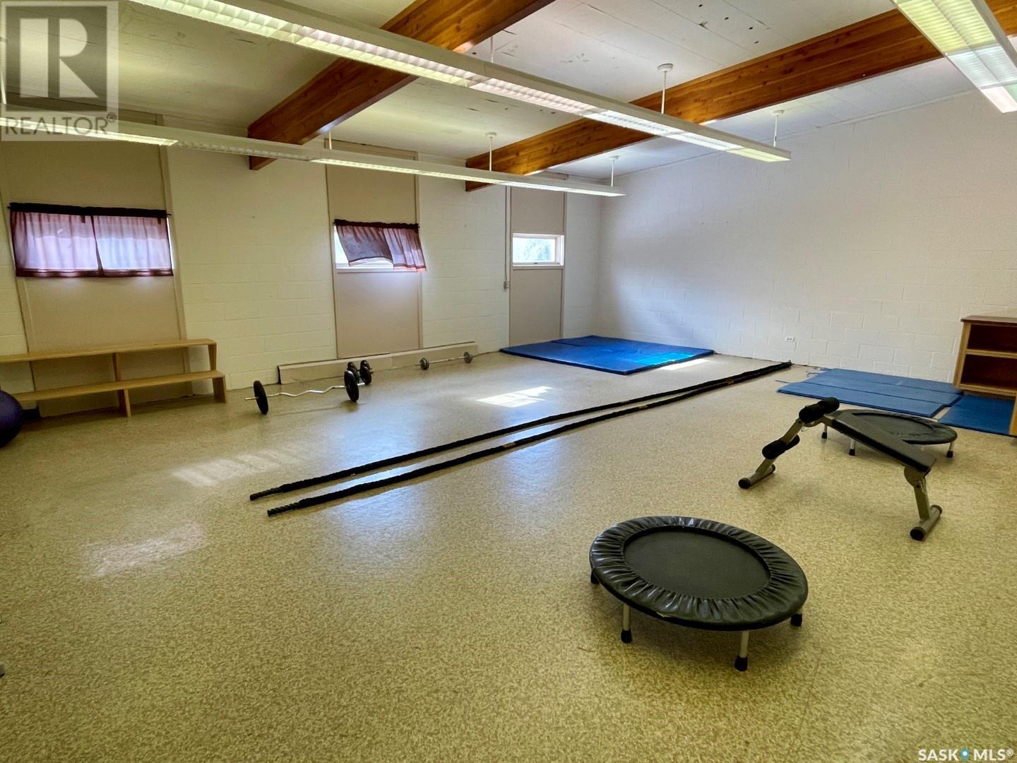 Current multi-purpose exercise room with wooden beams and basic equipment